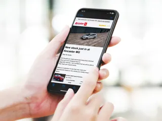 Hands holding a mobile phone with an article on the screen