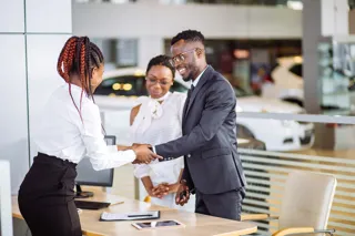 A stock picture of someone buying a car in a dealership