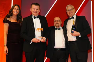 Mark Lavery, chief executive, Cambria Automobiles, accepts the award from AM editor Tim rose, second from right, Ian Simpson, sales and marketing director, Premia Solutions, right, and host Lisa Snowdon, left