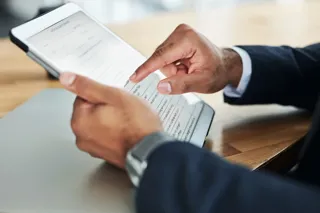 Cropped shot of an unrecognizable businessman using a digital tablet