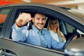 Car buyer celebrates by showing keys to a new vehicle