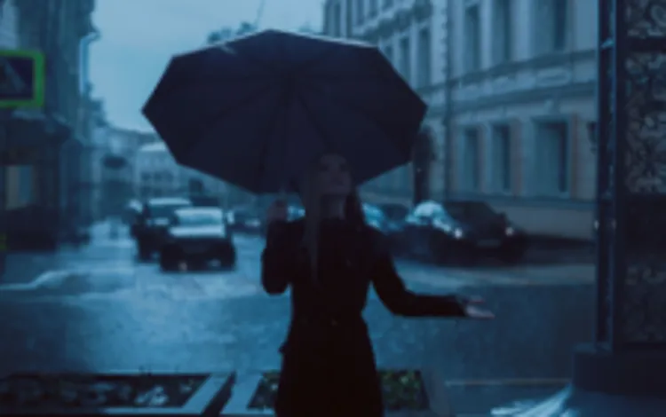 Woman standing under an umbrella in the rain