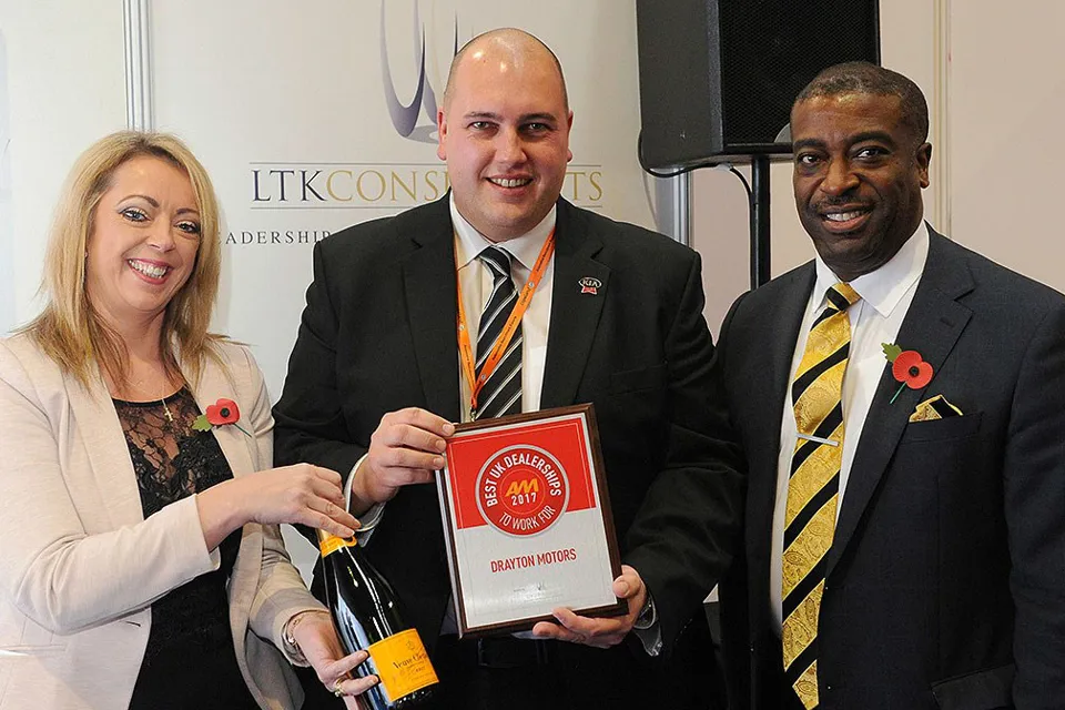 Darren Bradford, general manager,  Drayton Motors Kia, left, accepts the  AM Best UK Dealerships to Work For  award from LTK Consultants’  managing director, Andrew Landell